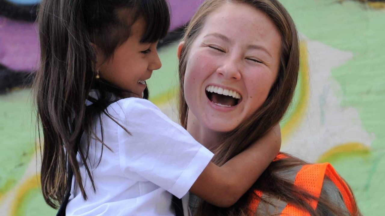 Student laughing with local girl