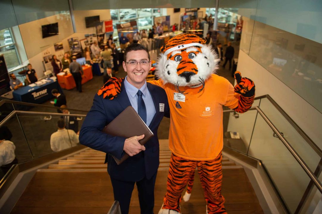 A male student with Aubie at a Career Fair