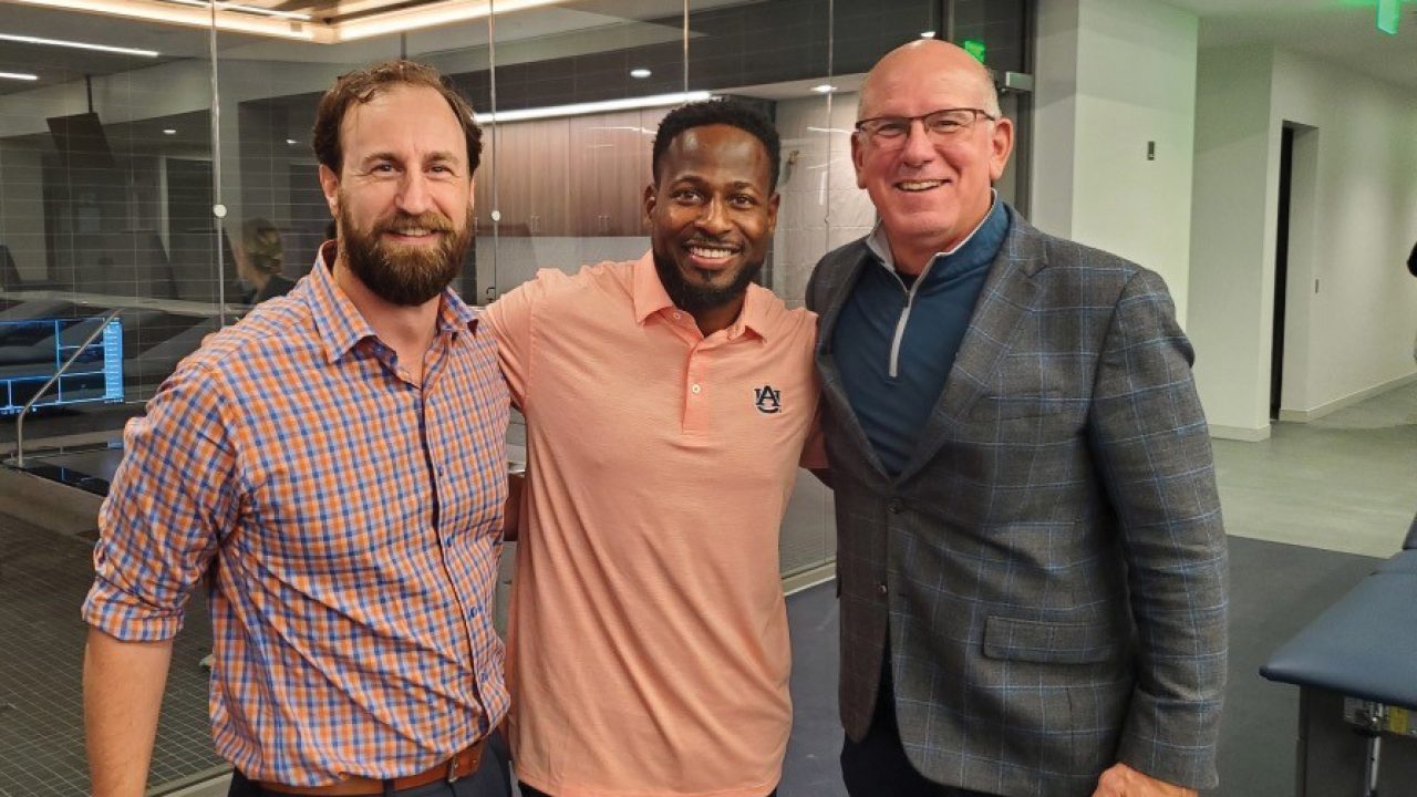Yann Cowart '88, pictured with Erik Consuegra '06 and Cadillac Williams