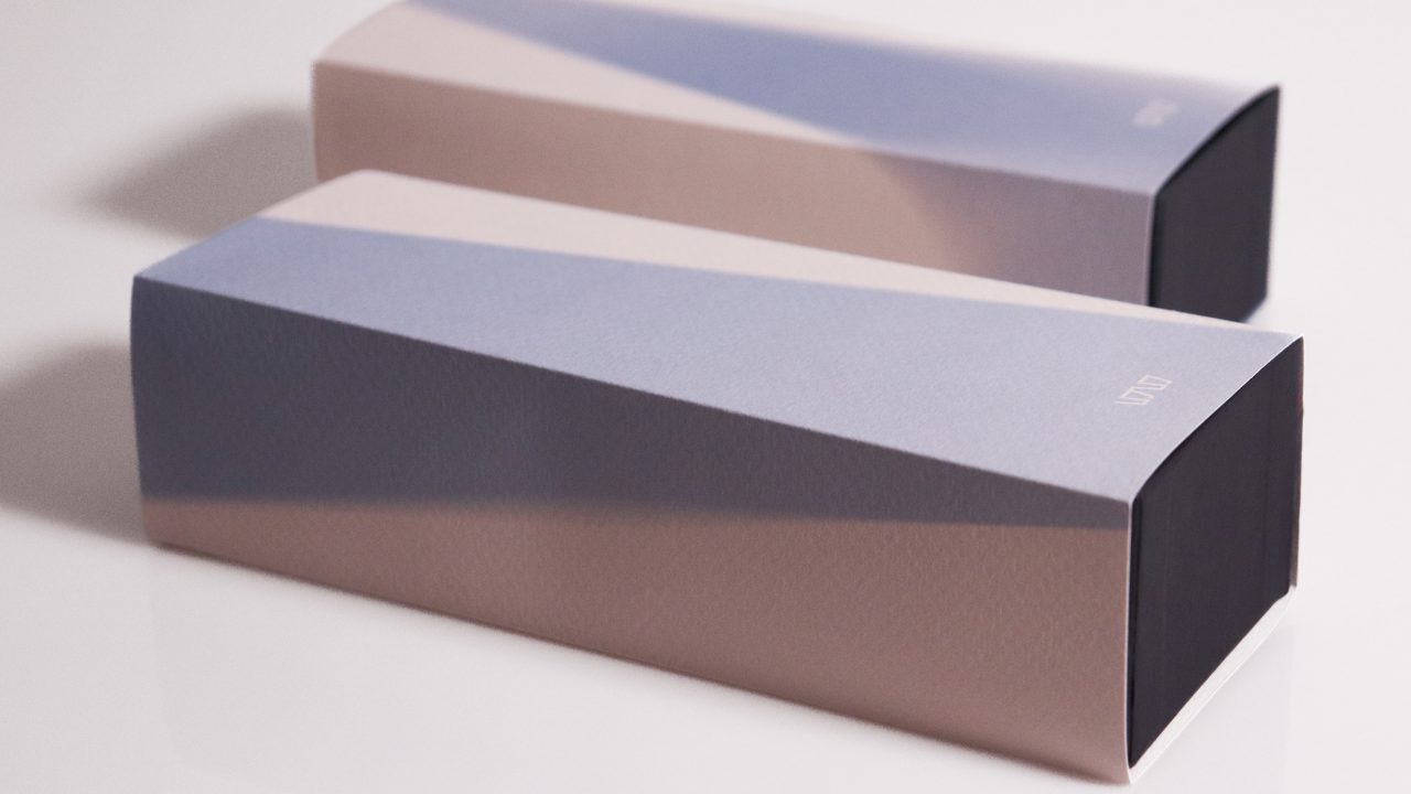 Two rectangular, pastel-colored boxes with a gradient design and dark ends are placed on a white surface.
