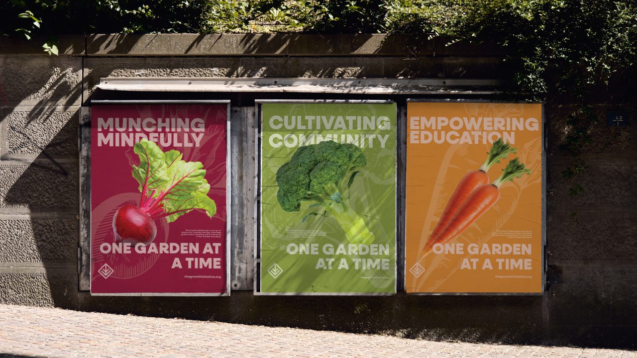 Three colorful posters on a wall show a beet, broccoli, and carrots with the slogans: Munching Mindfully, Cultivating Community, and Empowering Education; One Garden at a Time.