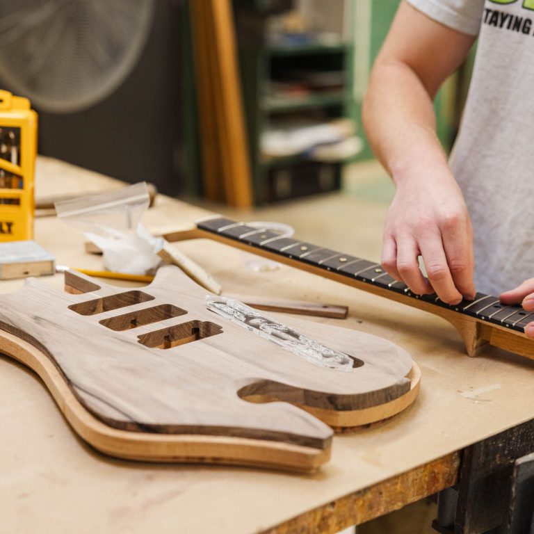 An INDD student in process of building their guitar base