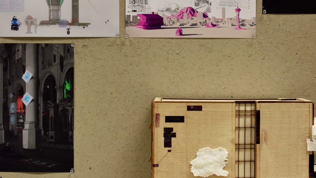 Auburn University Environmental Design student work A detailed architectural model sits on a table in front of a wall displaying various architectural drawings and visualizations.