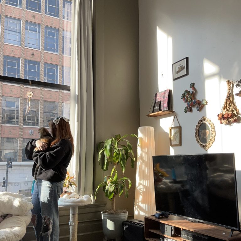 Abby Best, a fifth-year student, relaxes with her cat in her apartment at The William.