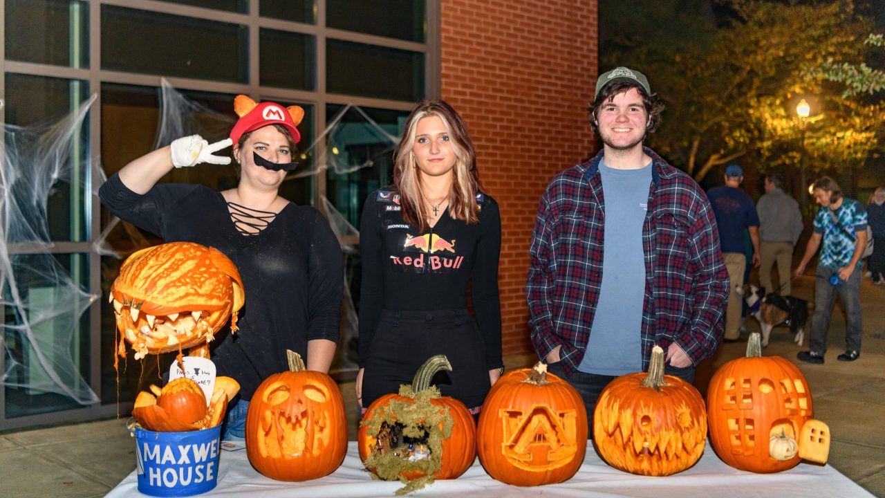 Winners stand beside their carved pumpkins at the close of the contest.
