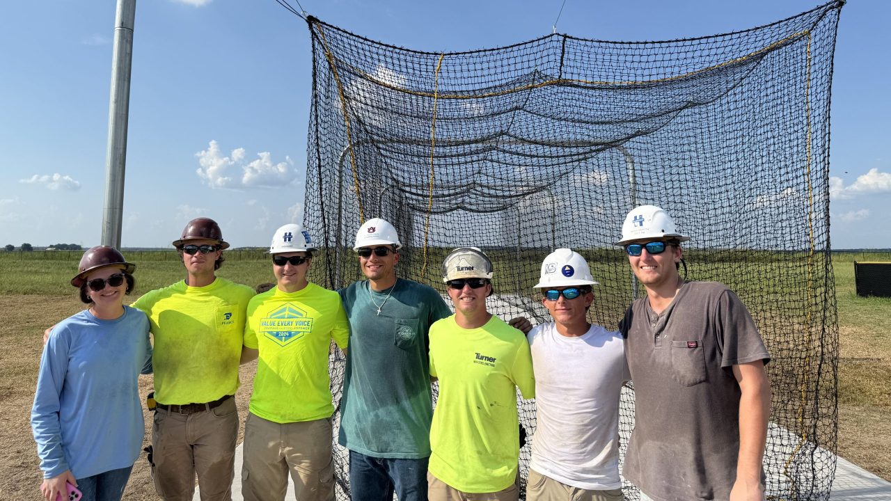 A group of people standing in front of a net.