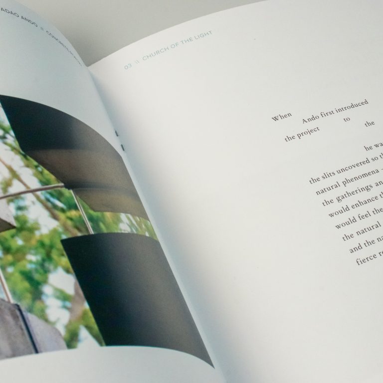 Open book showing a color photograph of a concrete cross with a window, and a page with partially obscured printed text about the “Church of the Light.”.
