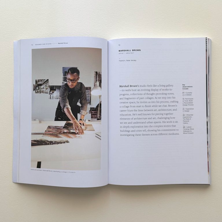 An open magazine displays a photo of a person arranging papers on a desk on the left page and text about Marshall Brown on the right page.