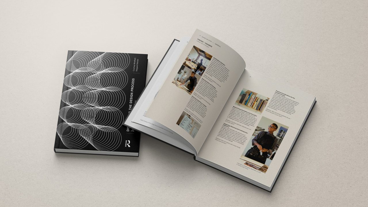 A closed and an open book are displayed on a light surface; the cover features geometric patterns, while the open pages show text and photos.