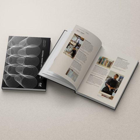 A closed and an open book are displayed on a light surface; the cover features geometric patterns, while the open pages show text and photos.