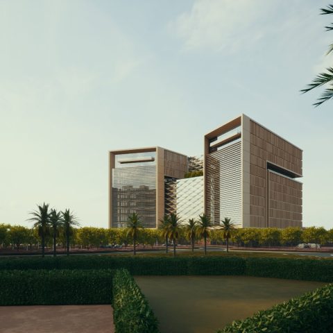 Modern office buildings with large rectangular frames, surrounded by palm trees and greenery under a clear sky.