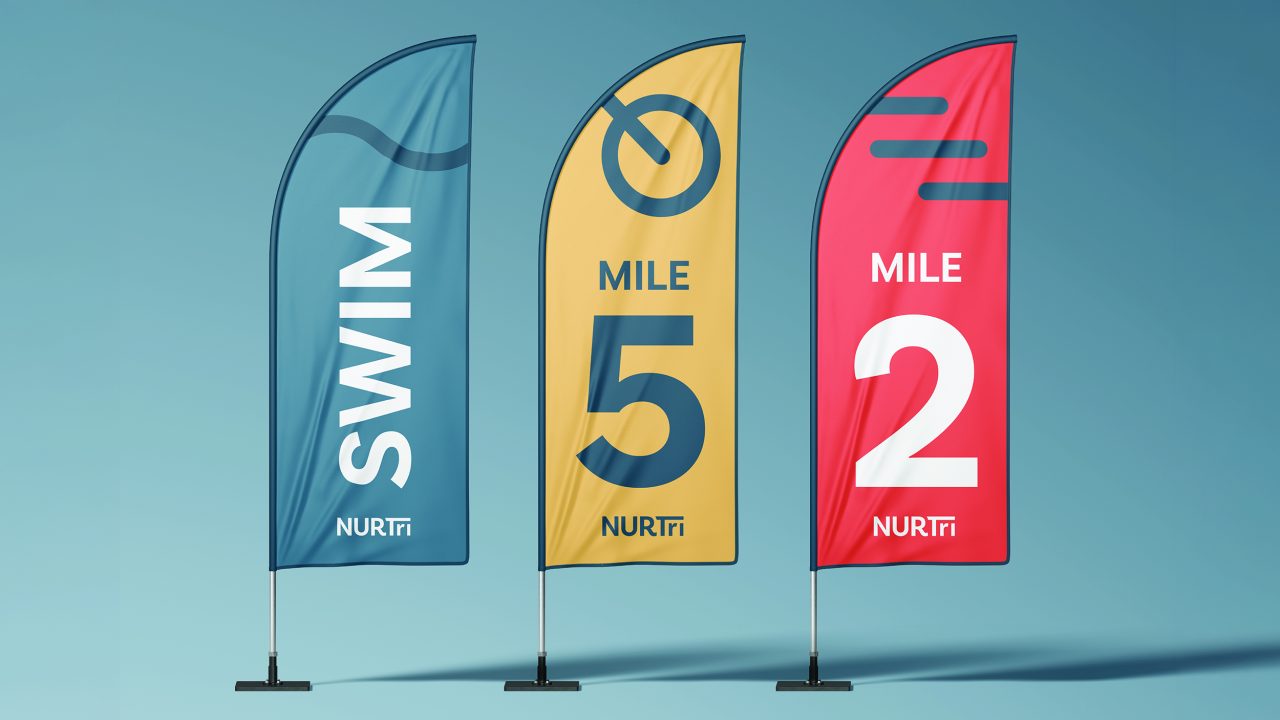 Three vertical flags on stands: a blue SWIM flag, a yellow MILE 5 flag, and a red MILE 2 flag, each labeled with the NURtri logo.