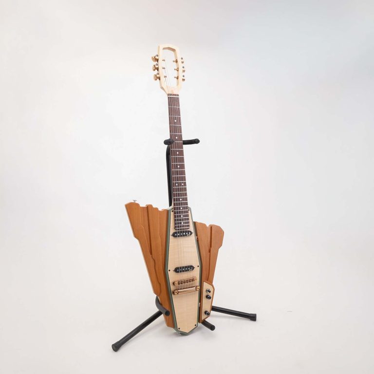 A guitar with a uniquely shaped, angular wooden body and headstock is displayed on a black stand against a plain white background.
