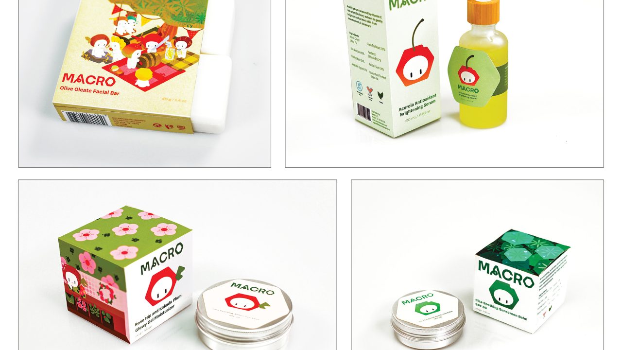Four skincare products with “MACRO” branding are displayed: a soap bar, a dropper bottle with box, and two jars with different colored boxes, all featuring a cartoon fruit logo.