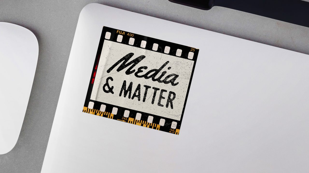 A laptop with a sticker resembling a film strip that reads Media & Matter in bold text.