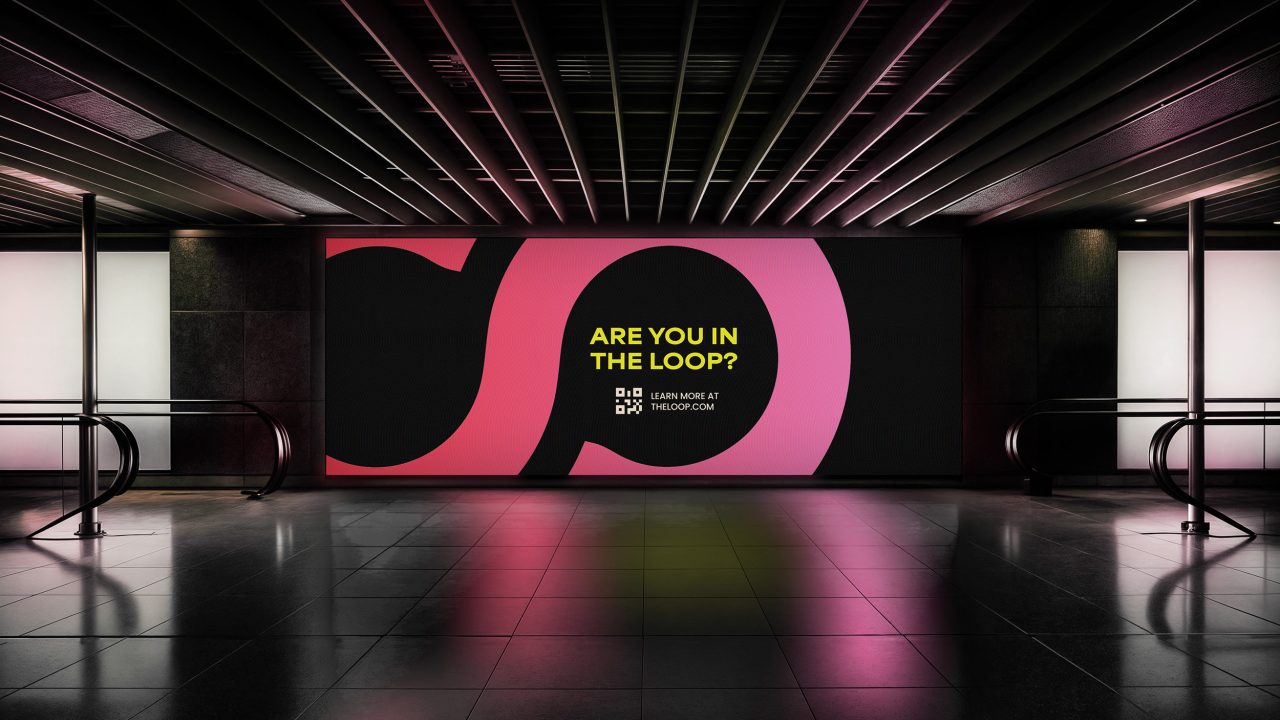 A large digital billboard in a modern, dimly lit space displays ARE YOU IN THE LOOP? with a QR code and abstract pink and black design elements.