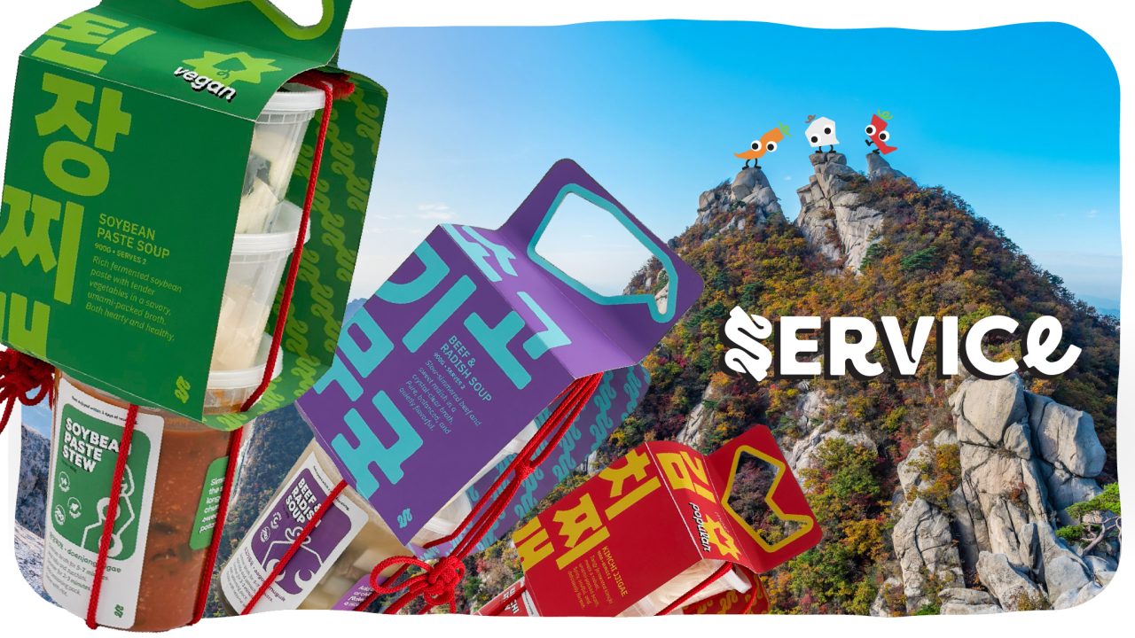 Colorful packaged soup products are displayed in the foreground, with a rocky mountain and cartoon rockets in the sky in the background, and the word SERVICE partially visible.