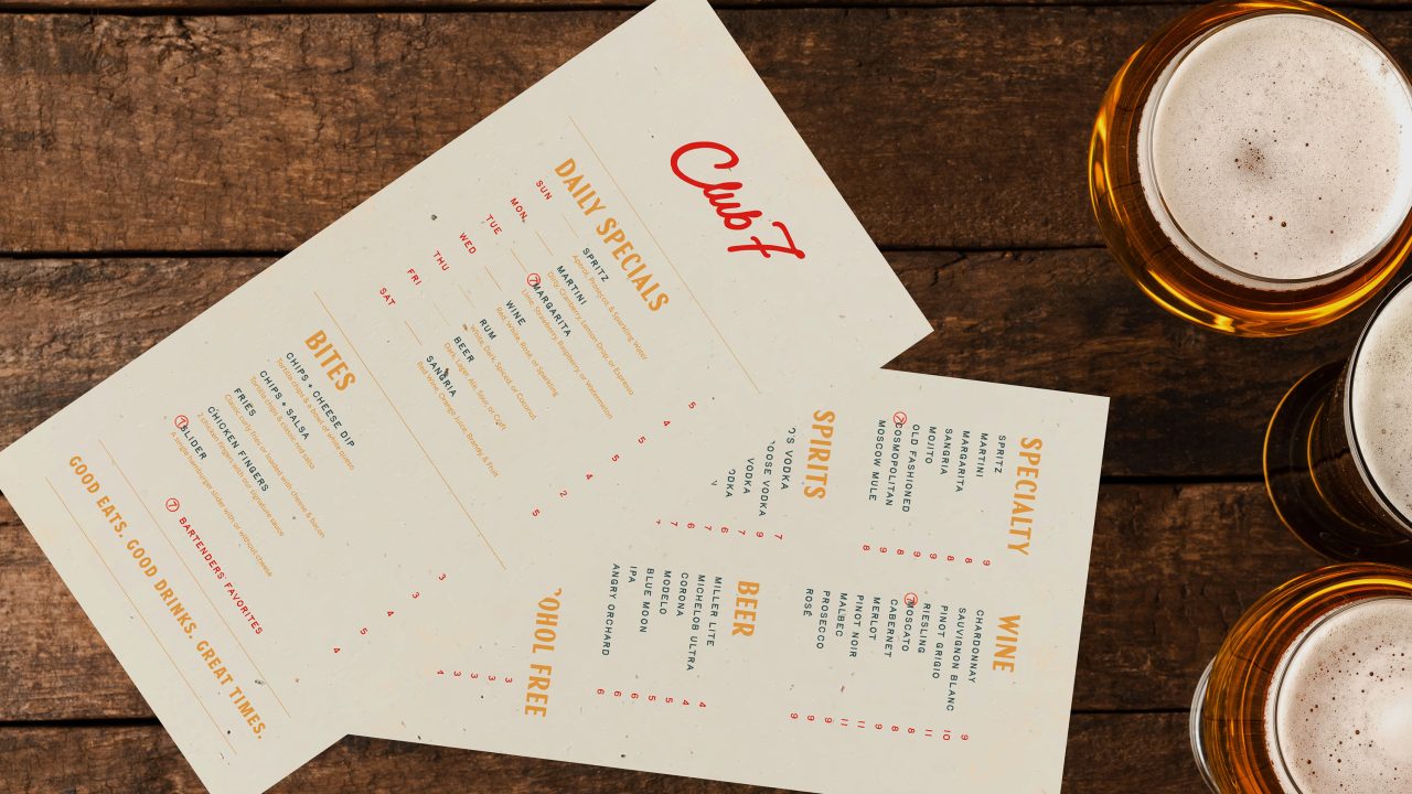 Two printed menus from Club 7 showing daily specials, food, and drink options are placed on a wooden table next to three glasses of beer.