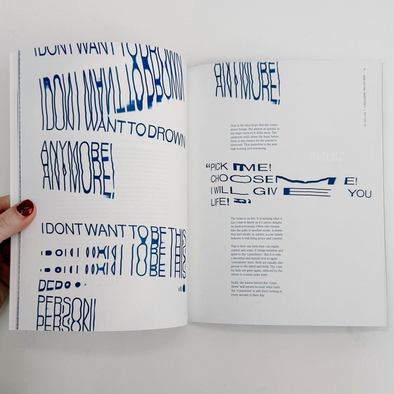 A hand holds open a book featuring blue, distorted text on white pages. The text is stretched and warped, creating an abstract visual effect.