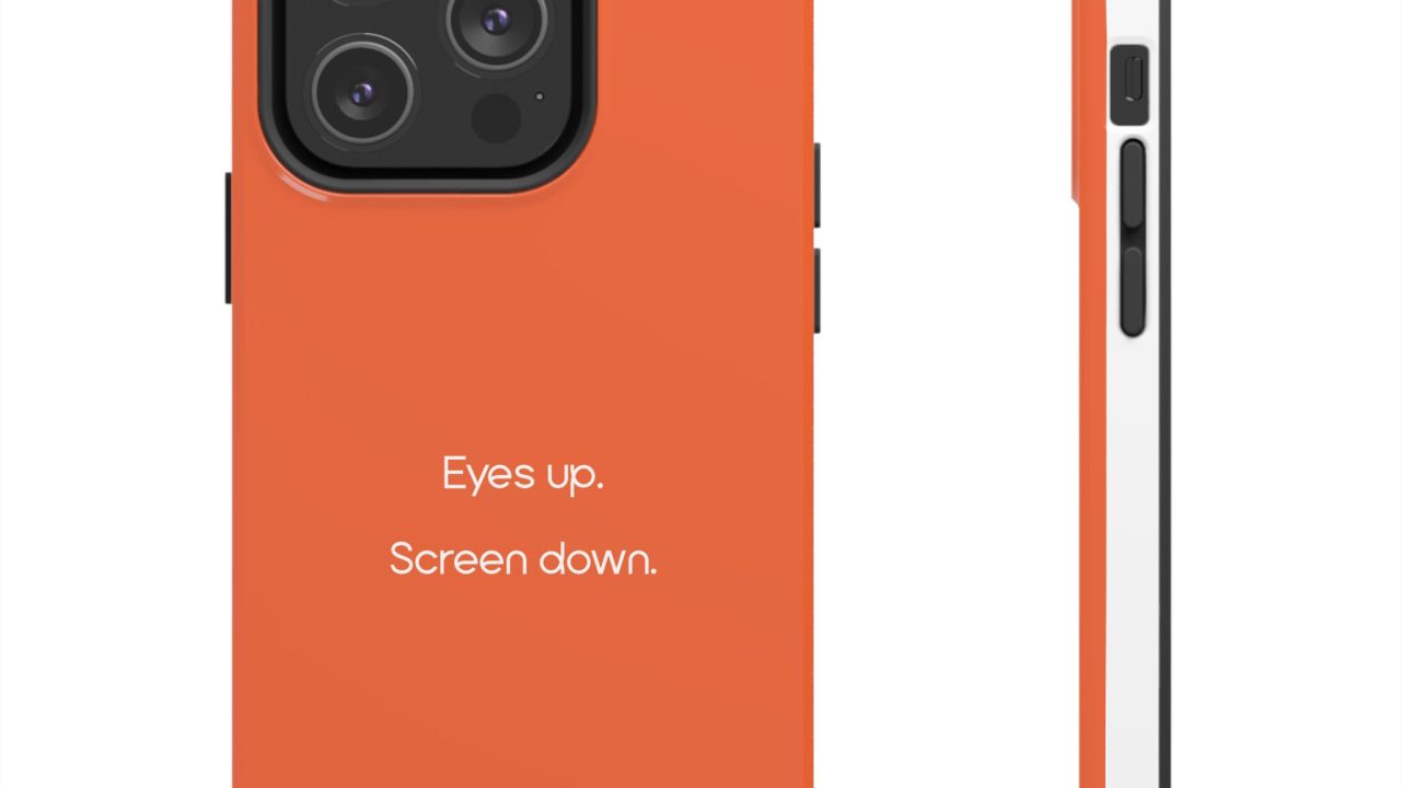 Orange phone case with three camera cutouts and the text Eyes up. Screen down. printed on the back, shown from the back and side.