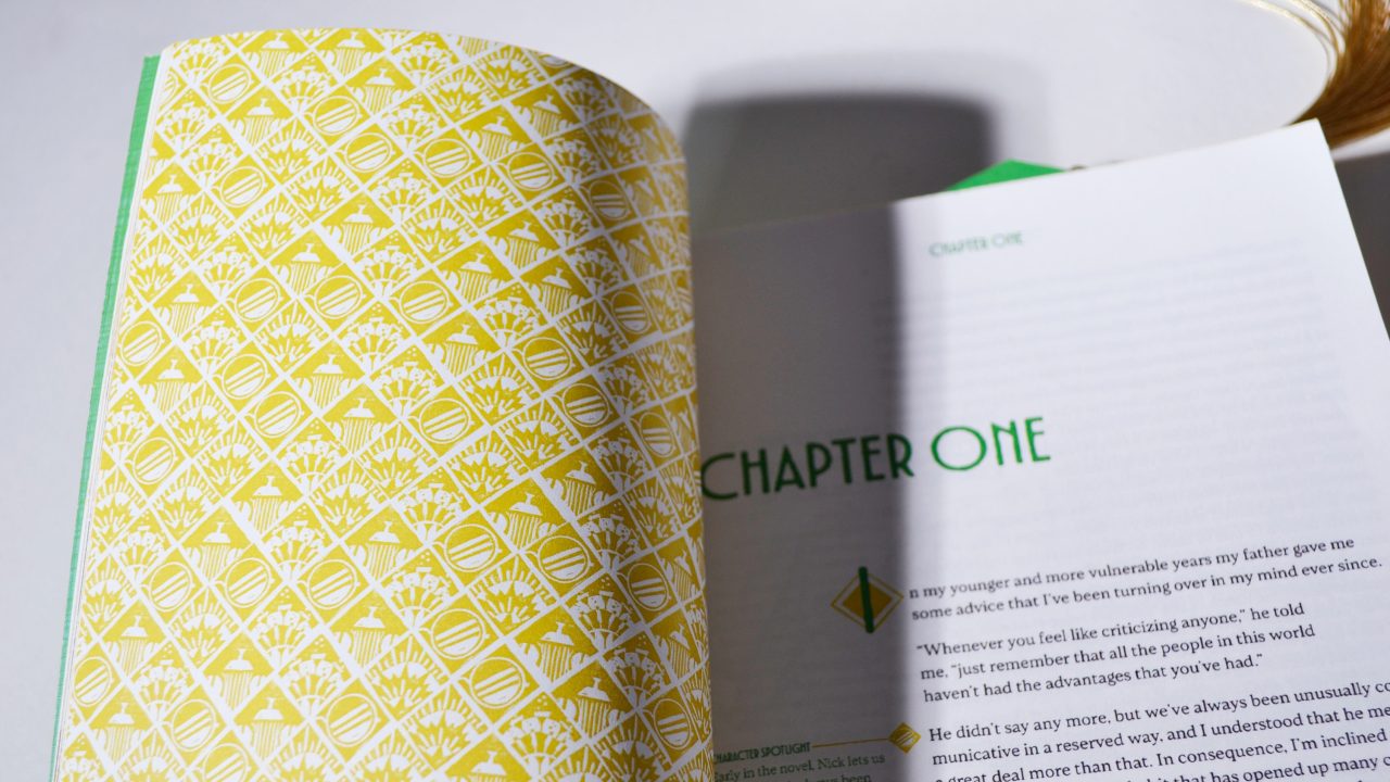 Open book displaying a yellow patterned endpaper on the left and the start of Chapter One with green text on the right.