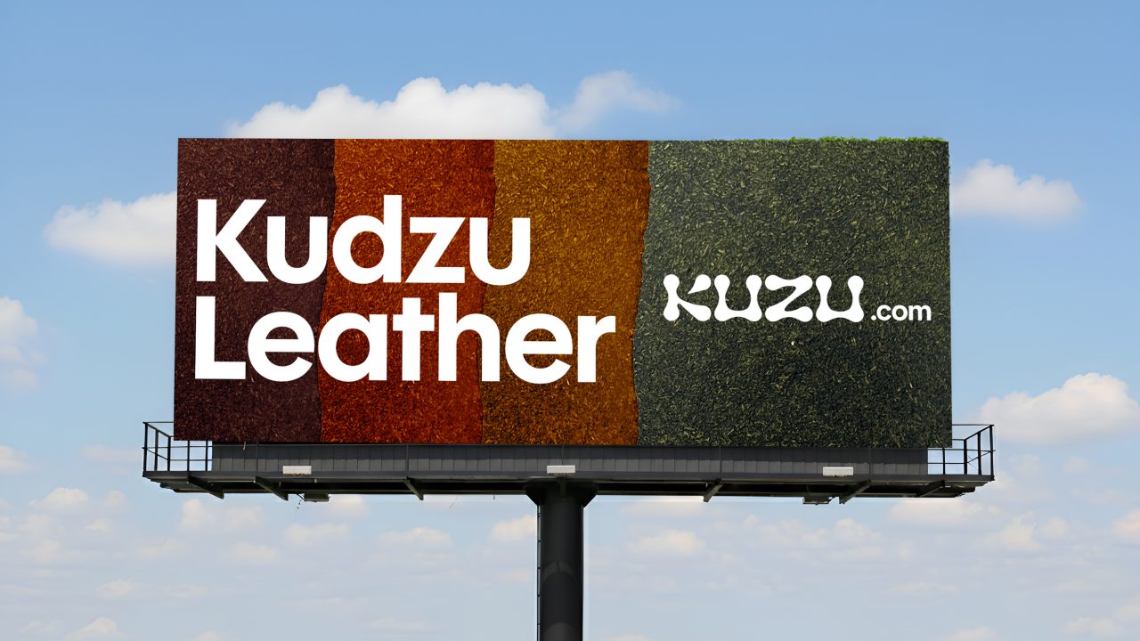 A billboard with textured colored stripes displays Kudzu Leather and kuzu.com against a partly cloudy sky.