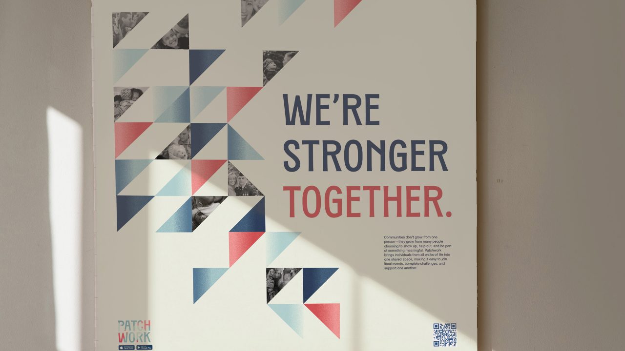 A poster on a wall features geometric patterns and the text WERE STRONGER TOGETHER. in large letters, with sunlight casting shadows beside it.