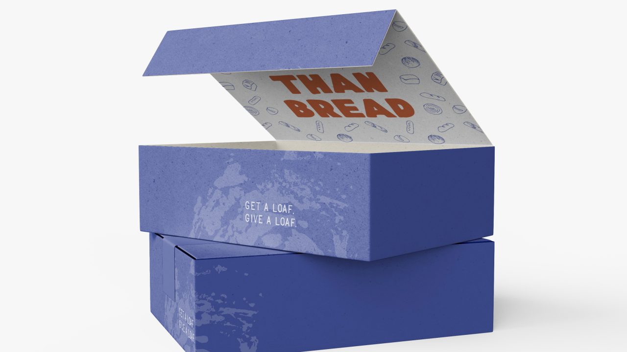 A blue rectangular box with the lid open, revealing the words THANKS BREAD printed inside and GET A LOAF GIVE A LOAF on the front.