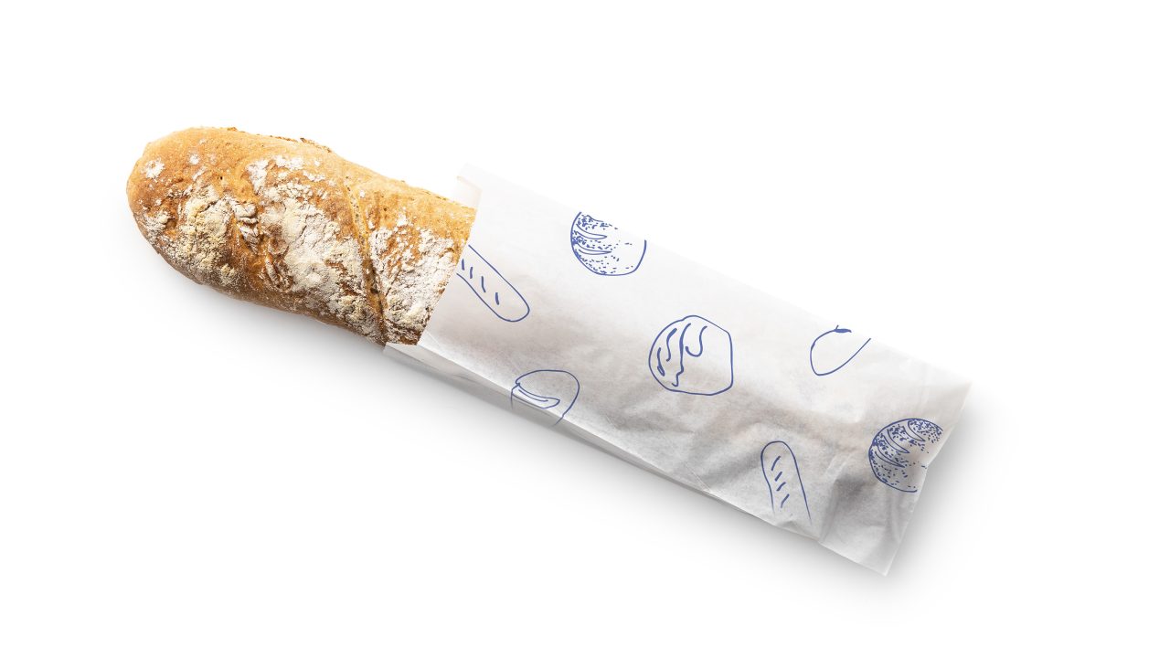 A rustic baguette partially wrapped in white paper with blue bread illustrations, placed on a white background.
