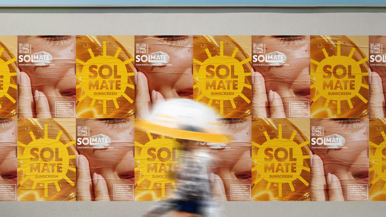 A person walks past a wall covered with repeated yellow posters advertising SOL MATE sunscreen, featuring a close-up of a face and a sun graphic.