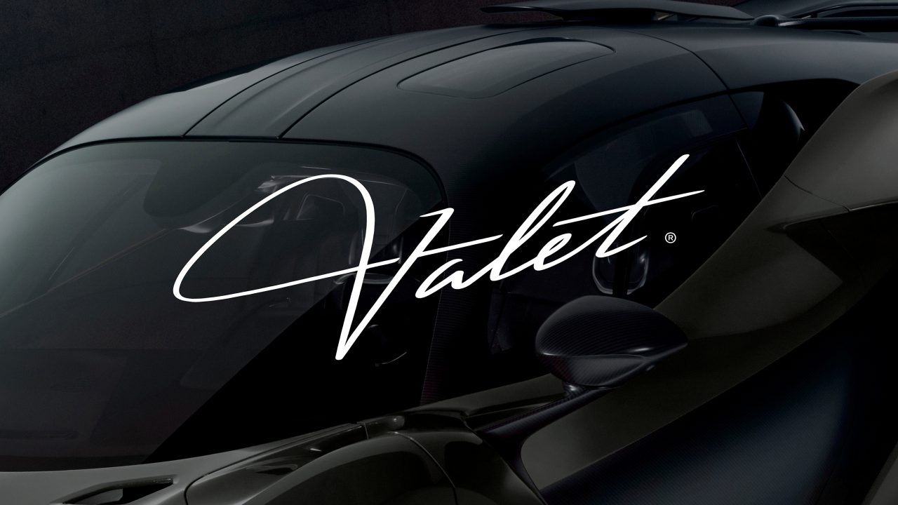 Close-up of a sleek, dark sports car with the word Valet written in elegant white script across the image.