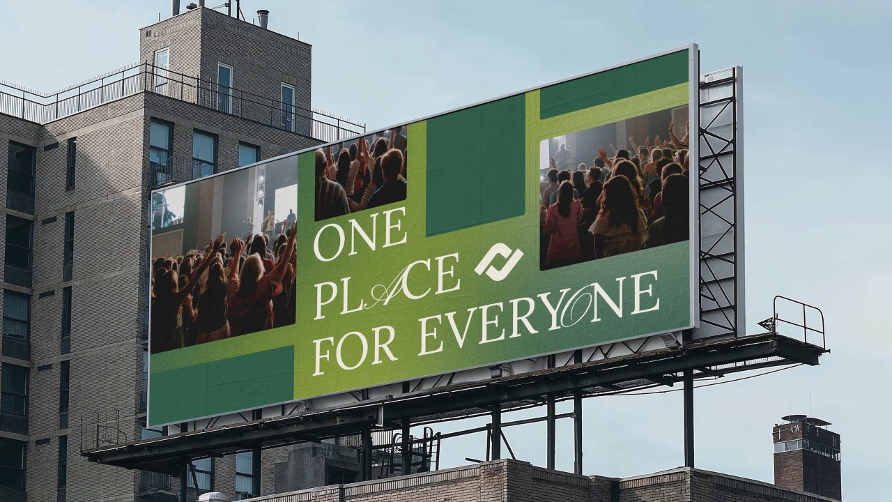 A large billboard on a building displays images of a crowd and the text ONE PLACE FOR EVERYONE in green and white.