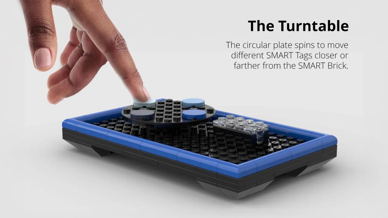 A hand spins a circular plate on a rectangular LEGO structure called The Turntable, designed to move SMART Tags closer or farther from a SMART Brick.