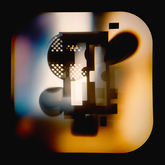 Abstract geometric shapes and patterns are seen in silhouette against a softly blurred, multicolored background.