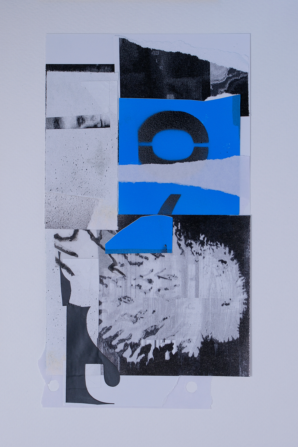 Abstract collage featuring torn blue, black, and white paper with geometric shapes, textures, and layered printed patterns on a white background.