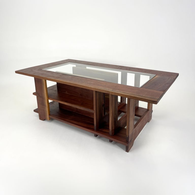 Rectangular wooden coffee table with a glass inset top, open shelving on the sides, and a central storage compartment, set against a plain white background.